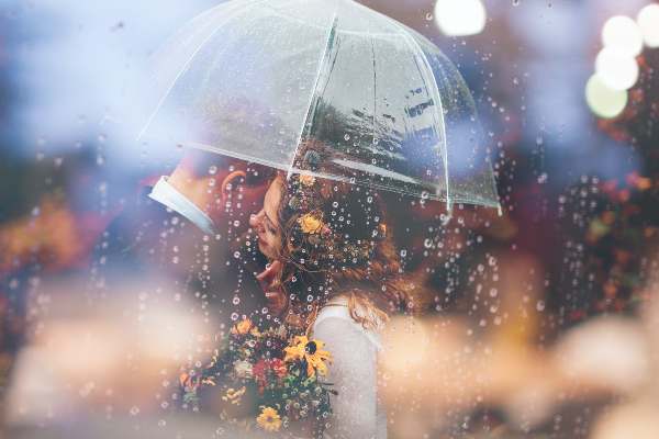 jeune mariés sous parapluie transparent